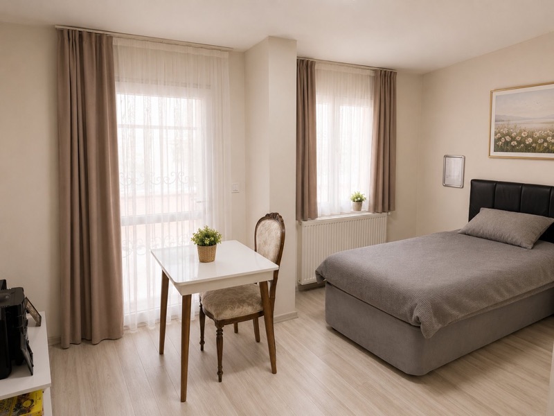 Tek kişilik oda: balkon kapısı, masa ve sandalye